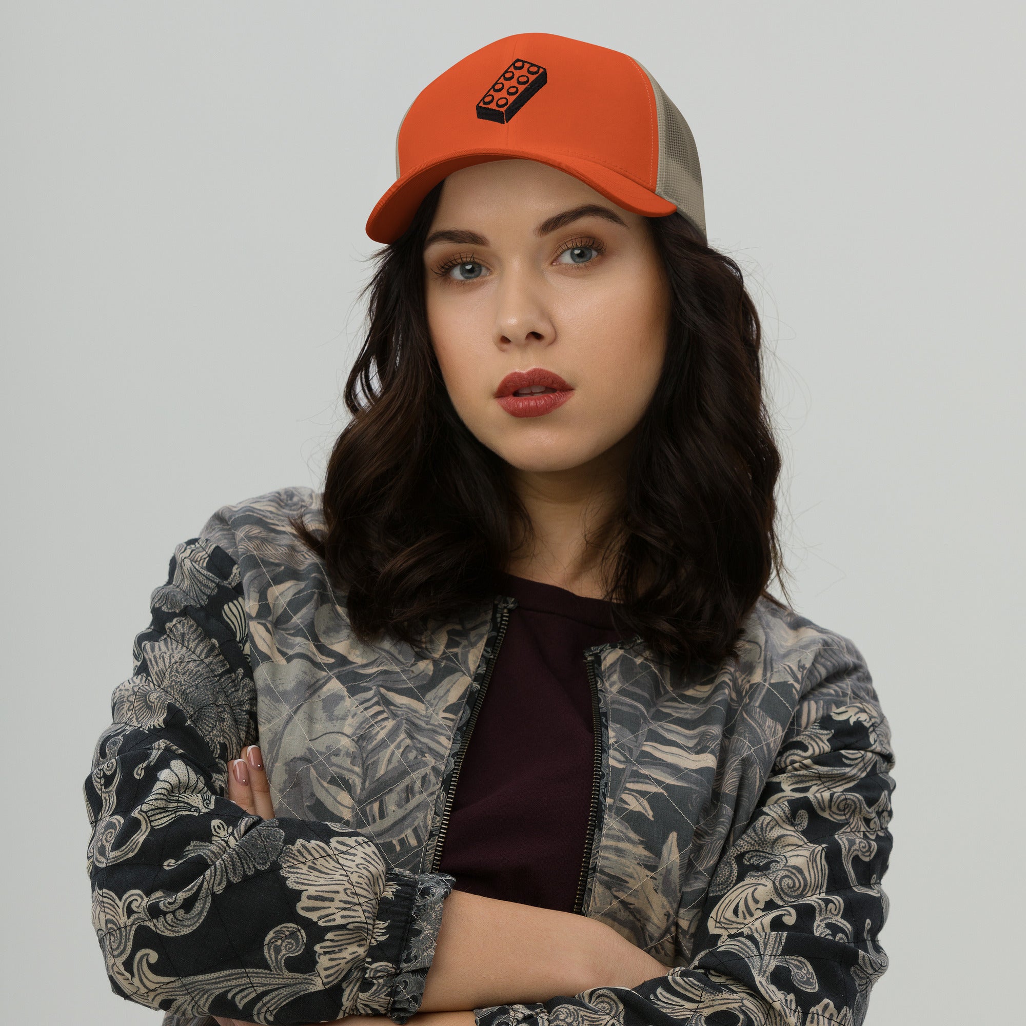 female model wearing an orange lego brick trucker hat